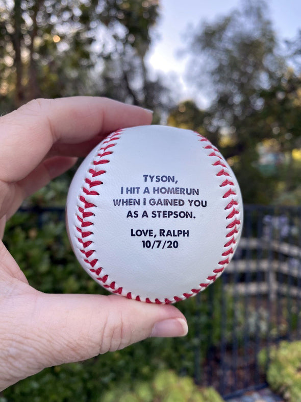 a regulation baseball with a saying about being a stepson